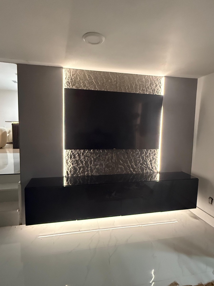 Textured stone media wall with LED outline and floating console